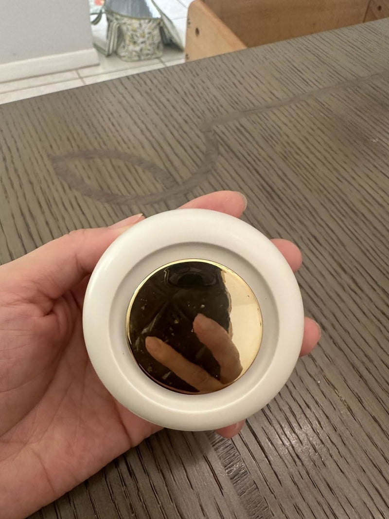 Review photo: the white clip-on bladeless fan held in a hand above a wooden table