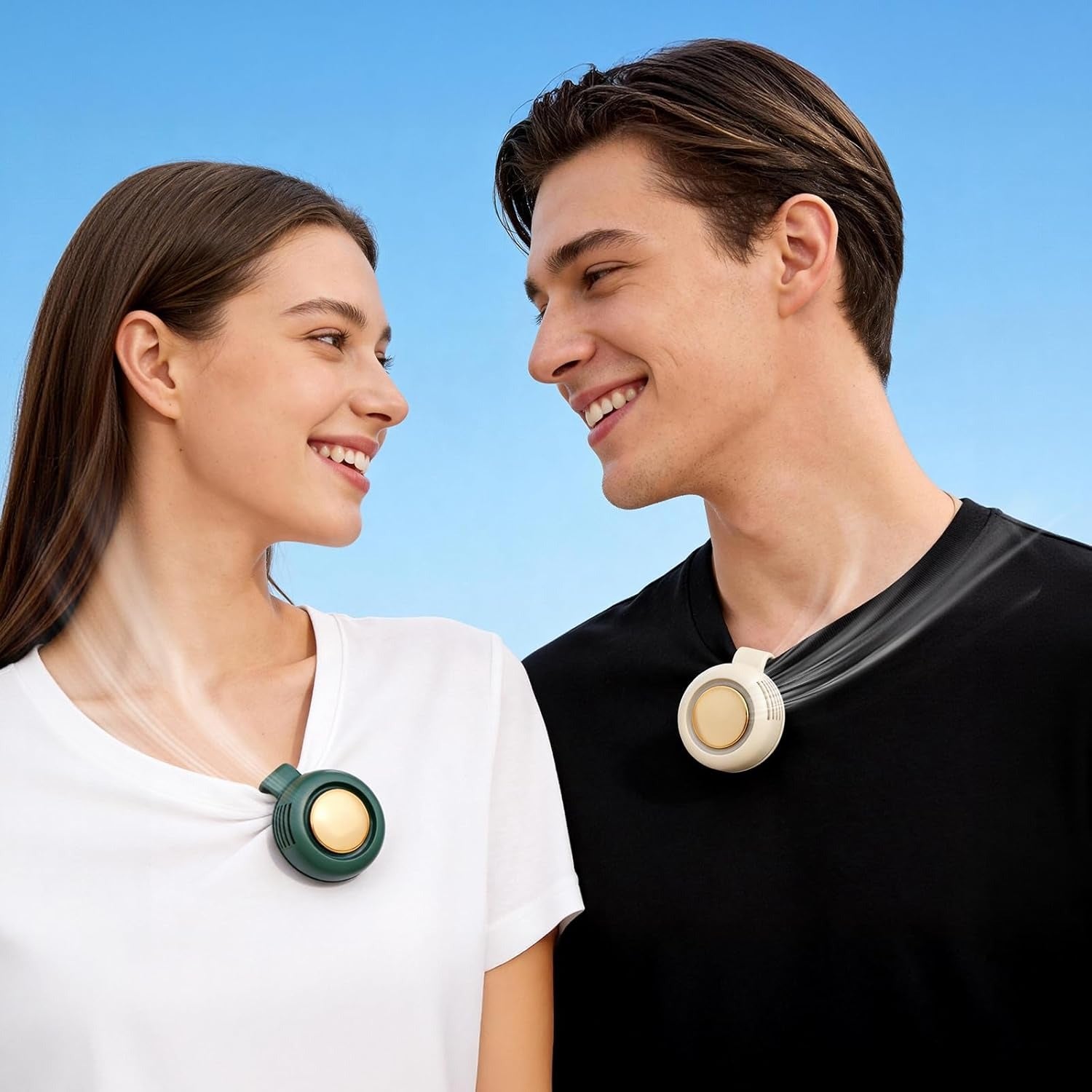 Two people side by side, each wearing the clip-on bladeless fan on their collar &mdash; one dark green, one white